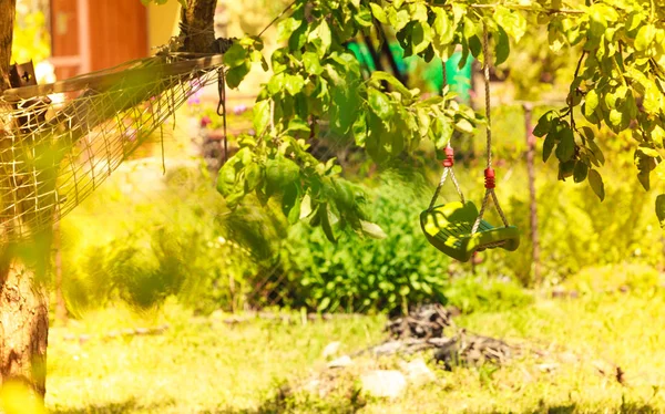 Plastikschaukel und Hängematte im Garten — Stockfoto