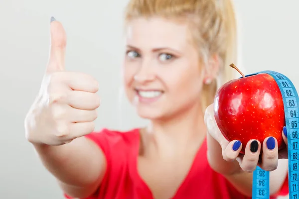 Mujer feliz sosteniendo manzana y cinta métrica — Foto de Stock