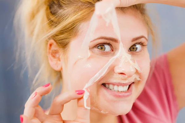 Kvinna som skalar av gelmask från face — Stockfoto
