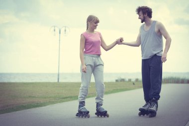 Genç bir çift paten yaparken elele