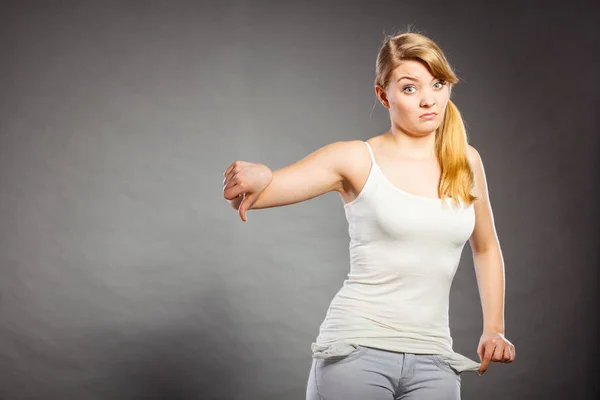 Upset sad woman showing empty pockets — Stock Photo, Image