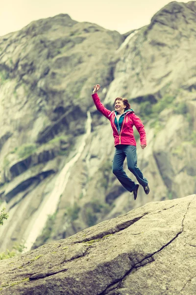 Happy woman jumping on rock in mountains — Stock Photo, Image