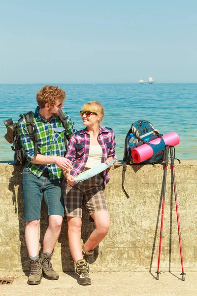 Mochileiro casal com mapa à beira-mar — Fotografia de Stock
