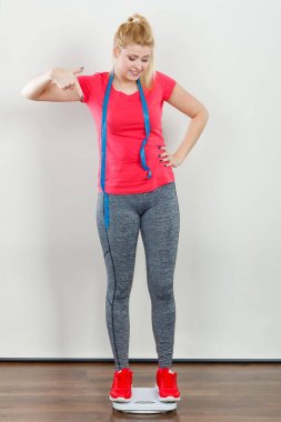 Spor giyim ayakta ağırlık makinede giyen kadın