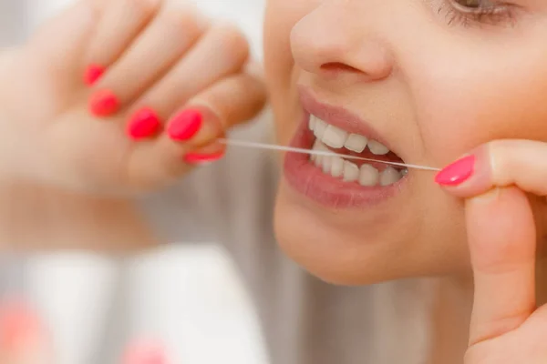 Kvinna rengöring av tänderna med tandtråd — Stockfoto