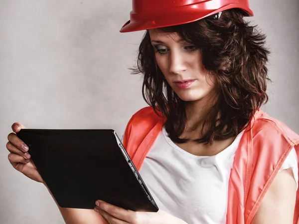 Sexy girl in safety helmet using tablet touchpad — Stock Photo, Image