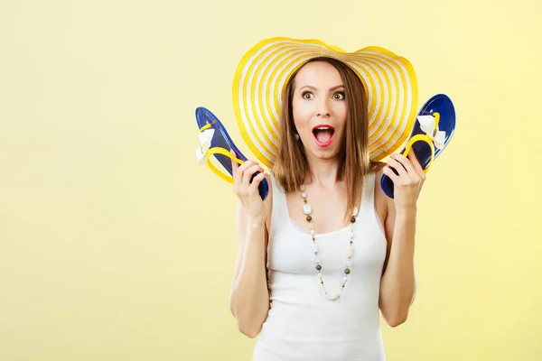 Woman in big yellow summer hat holds flip flops — Stock Photo, Image