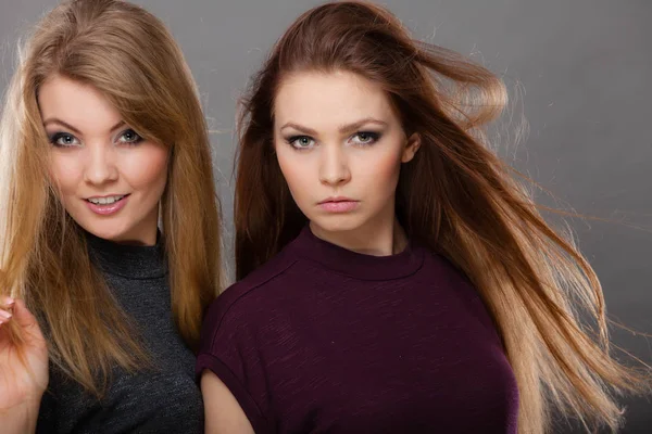 Две красивые женщины, блондинка и брюнетка позируют — стоковое фото
