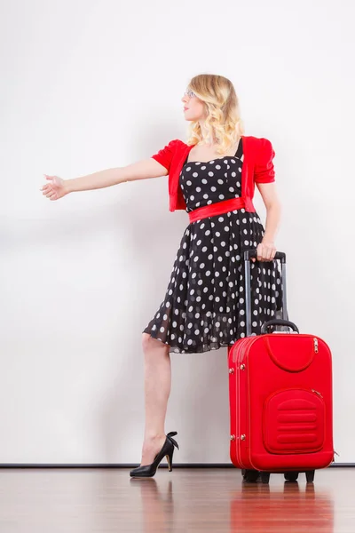 Kobieta z czerwoną walizkę autostopem — Zdjęcie stockowe