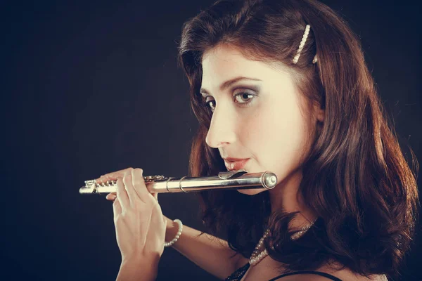Woman playing transverse flute on black. — Stock Photo, Image