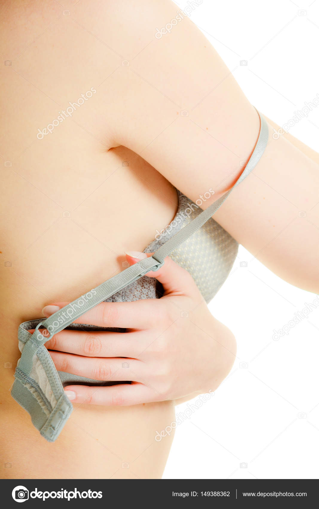 Woman putting on or taking off bra lingerie. Stock Photo by