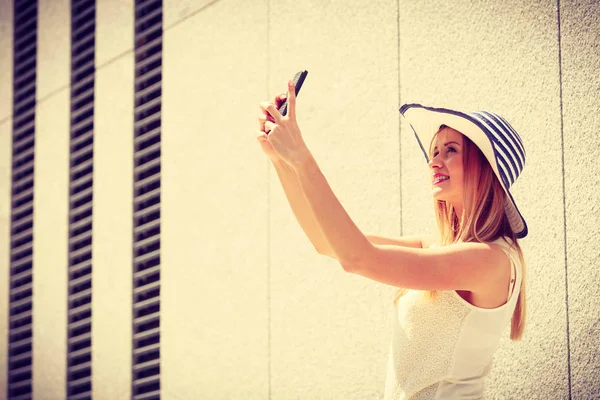 Jonge vrouw nemen selfie met smartphone buiten — Stockfoto