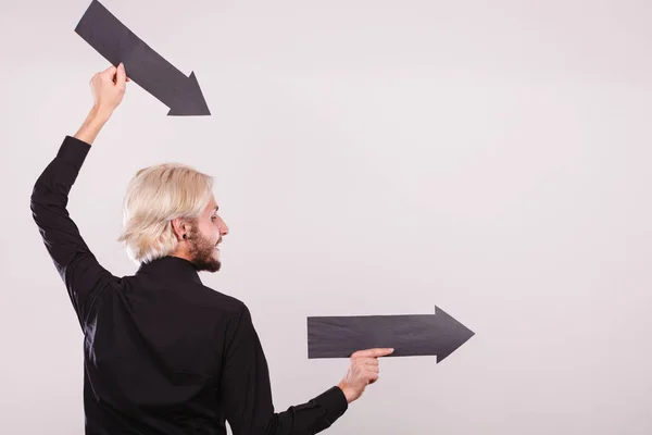 Hombre sosteniendo dos flechas apuntando en la misma dirección — Foto de Stock