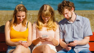 Arkadaşlar adam ve kadın cep telefonunu kullanarak.