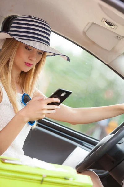 Mujer usando el teléfono mientras conduce su coche — Foto de Stock