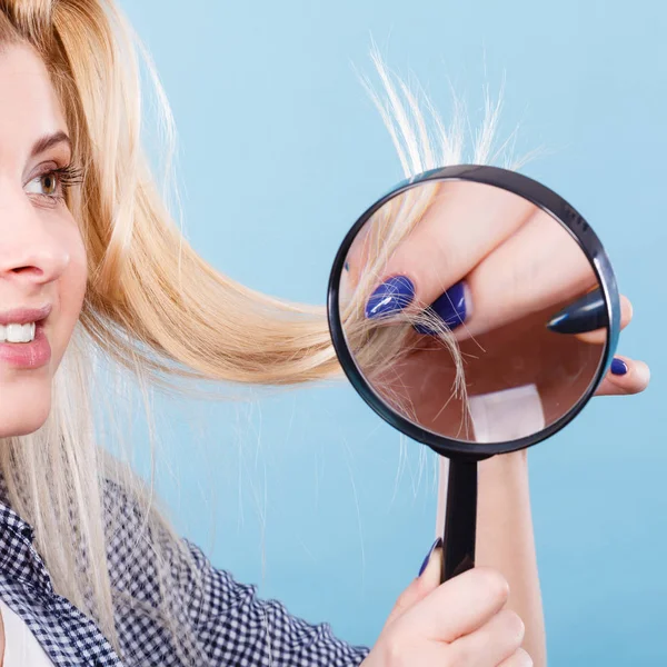 Mulher olhando para o cabelo através de lupa — Fotografia de Stock