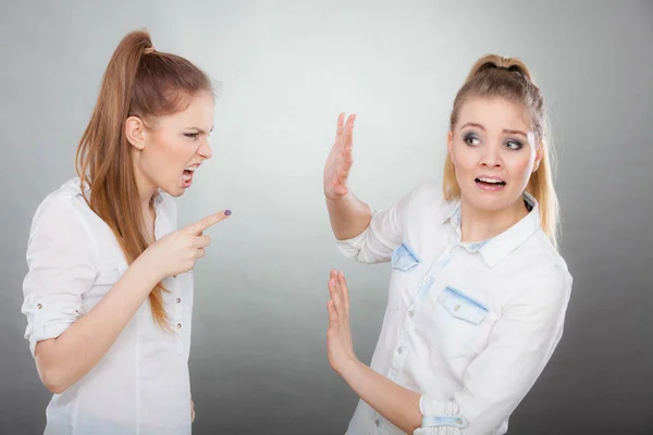 Злая яростная девушка кричит на свою подругу или младшую сестру — стоковое фото
