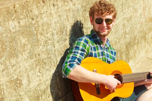 Young bebaarde hipster man met gitaar buiten — Stockfoto