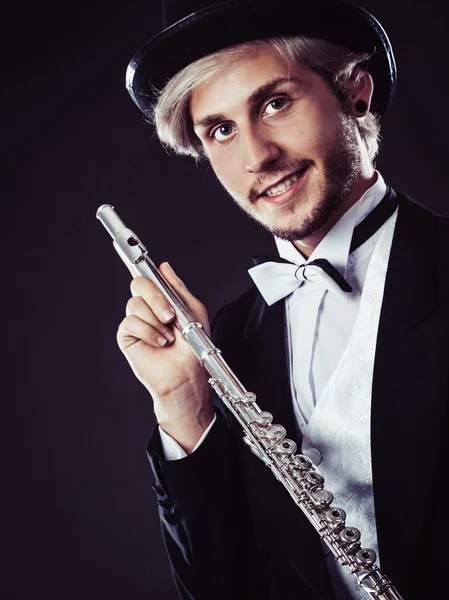 Элегантно одетый музыкант держит флейту — стоковое фото