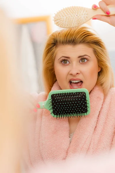 Scioccato donna indossa vestaglia spazzolando i capelli — Foto Stock