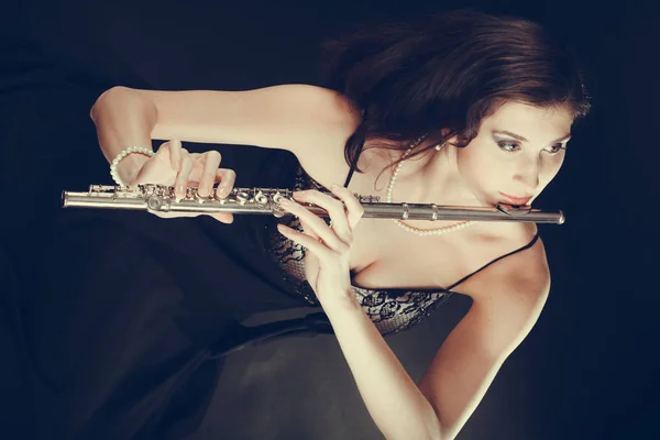 Mulher tocando flauta transversal no preto . — Fotografia de Stock