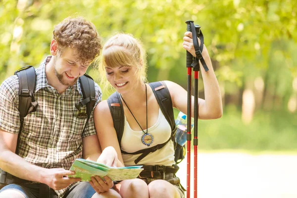 Excursionistas mochileros pareja lectura mapa en viaje . — Foto de Stock