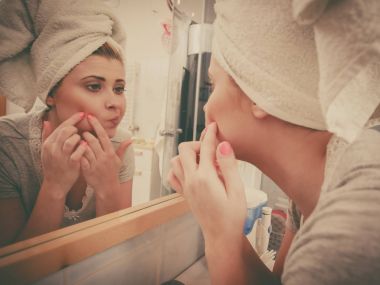 Akne başa ayna arayan kadın