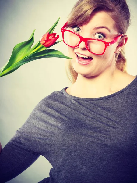 Speels meisje met plezier met bloem tulip. — Stockfoto