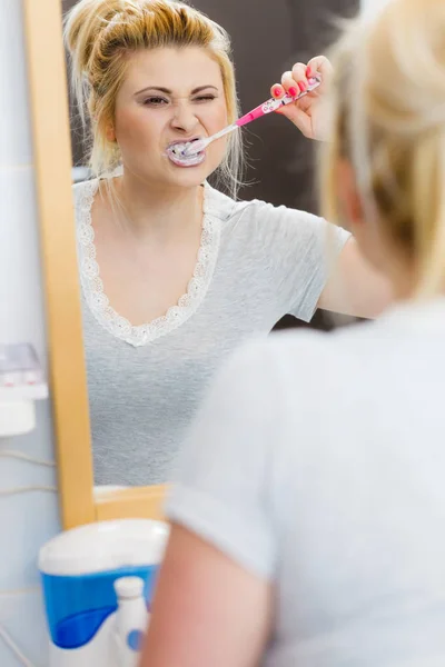 Woman brushing cleaning teeth in bathroom — Stock Photo, Image