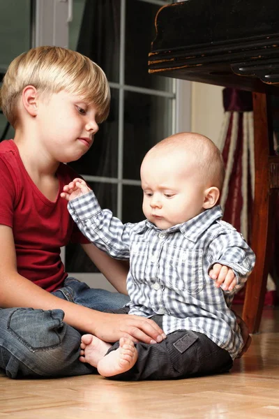 Маленький мальчик играет с братом — стоковое фото