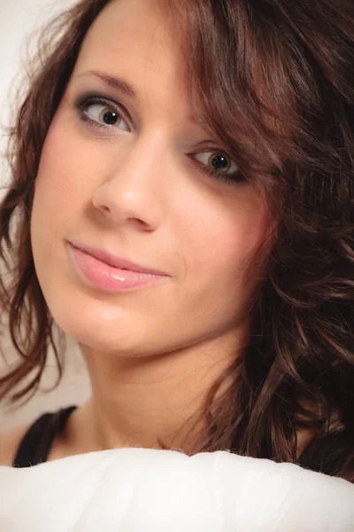 Portrait girl with pillow. Woman with curly hair — Stock Photo, Image