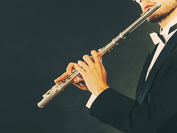 Elegantně oblečený muž hudebníka, hrajícího na flétnu — Stock fotografie