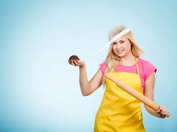 Mulher segurando cupcake, rolando pino vestindo escorredor na cabeça — Fotografia de Stock