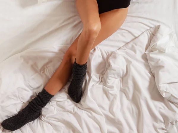 Sexy pernas femininas em meias na cama no quarto — Fotografia de Stock