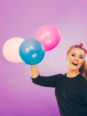 Balonlarla eğleniyor gülümseyen çılgın kız.