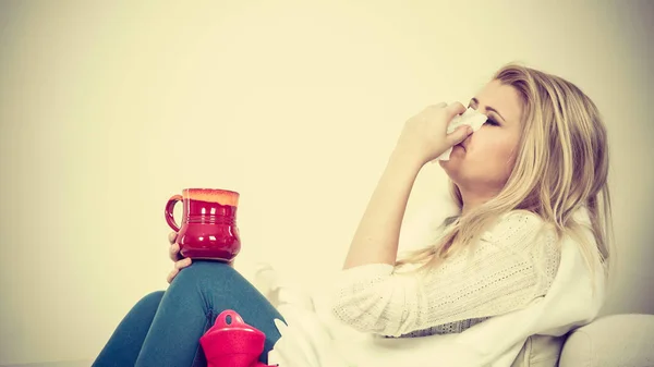 Mujer enferma teniendo gripe acostada en un sofá —  Fotos de Stock