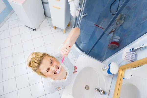 Mujer cepillarse los dientes de limpieza en el baño — Foto de Stock