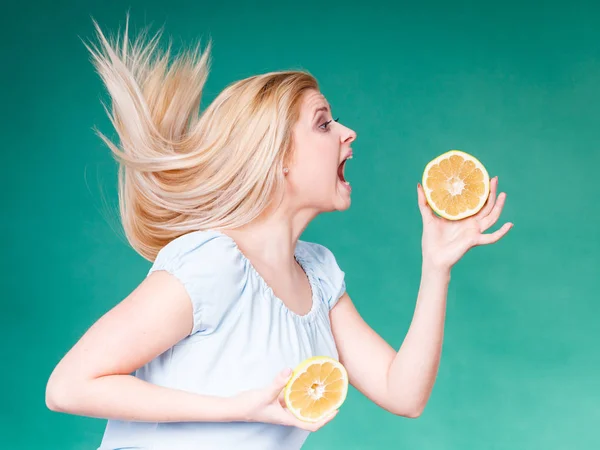 Vrouw met open mond houden grapefruit — Stockfoto