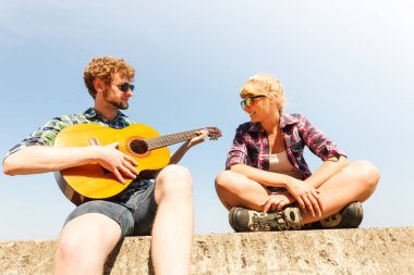 Genç kadın için gitar çalmak hipster adam.
