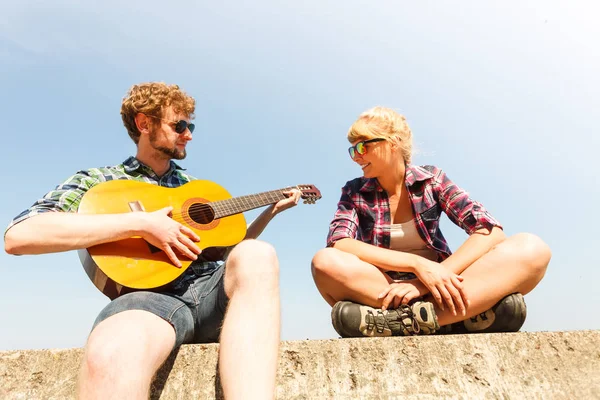 Młody człowiek hipster gry na gitarze dla kobiety. — Zdjęcie stockowe