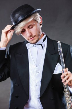 Zarif giyimli müzisyen flüt tutan