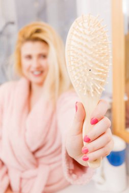 Onun saç fırçası gösterilen tutan mutlu kadın