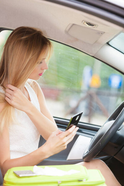 Женщина за рулём машины пользуется телефоном
