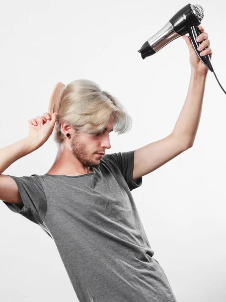 Joven hombre secando el cabello con secador de pelo — Foto de Stock