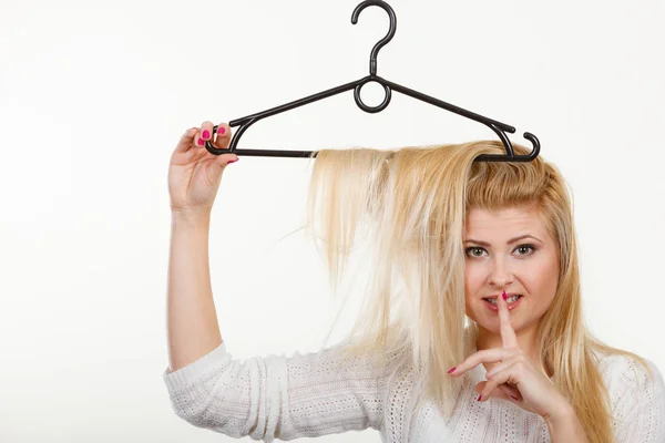 Mulher loira segurando o cabelo no cabide de roupas — Fotografia de Stock