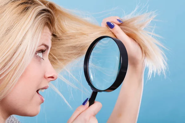 Mujer mirando el cabello a través de lupa —  Fotos de Stock