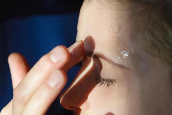 Young woman applying gel mask on face — Stock Photo, Image