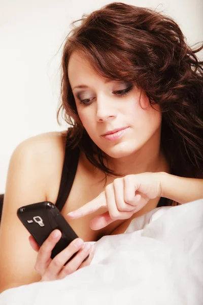 Sexy fille paresseuse couché avec téléphone sur le lit dans la chambre — Photo