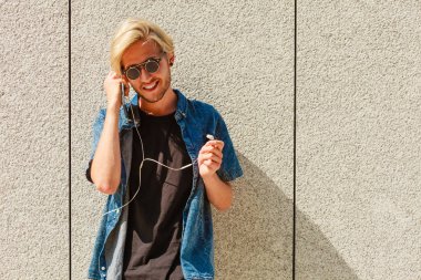 Kulaklık aracılığıyla müzik dinleme gülümseyen hipster adam