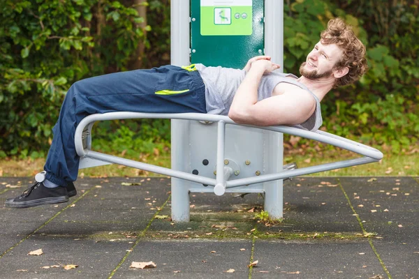 Активный человек тренируется на скамейке под открытым небом . — стоковое фото